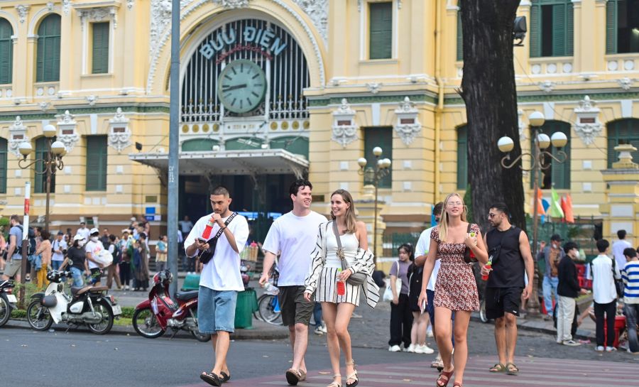 Tourists cross street nearby Saigon Central Post Office